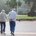 49795074 couple walking on the promenade on a sunny day