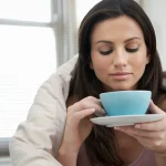 75394308 woman wrapped with duvet drinking tea