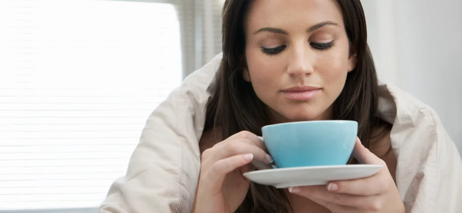 75394308 woman wrapped with duvet drinking tea